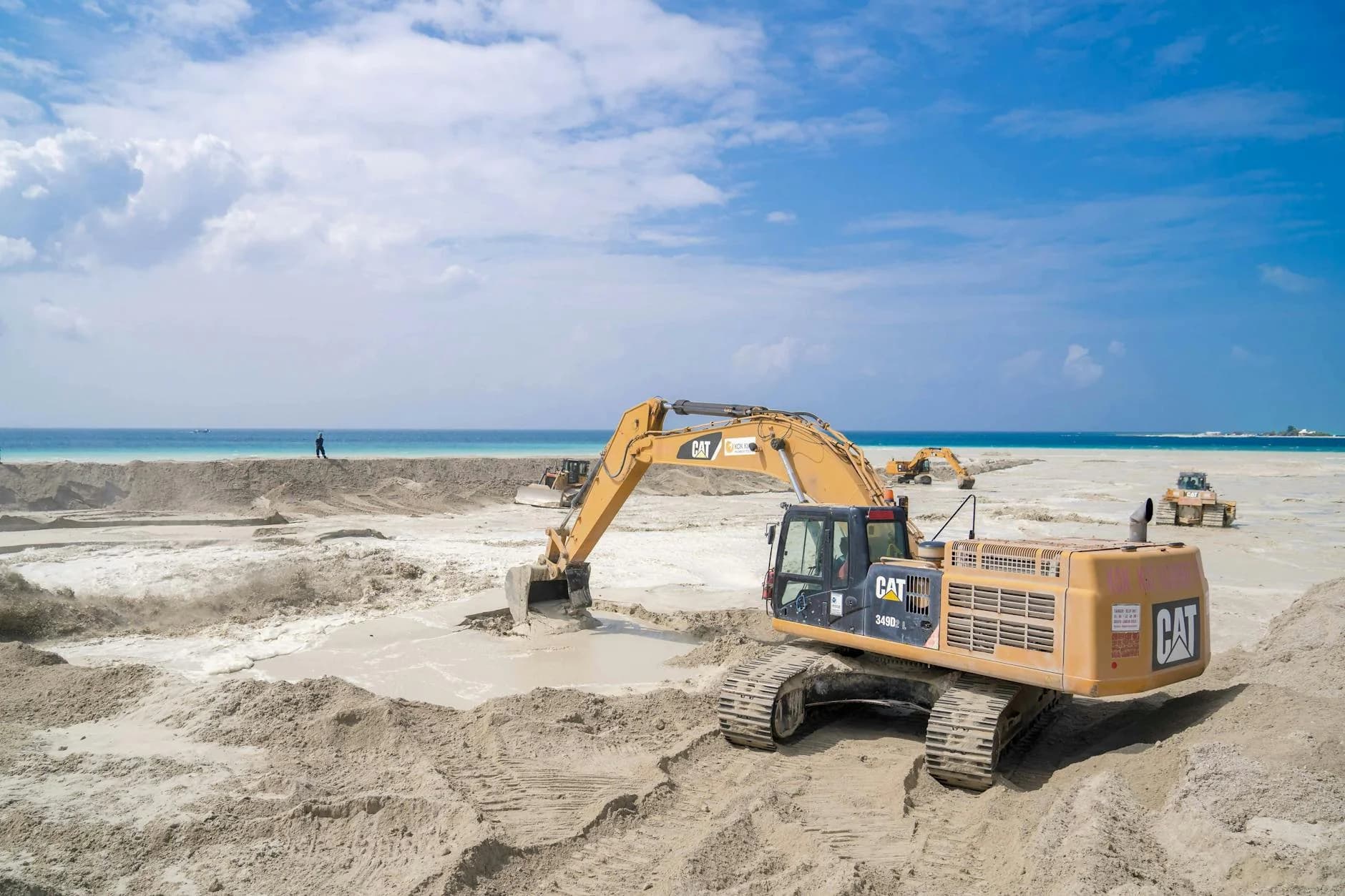 An Excavator Working On A Sandy Beach Co 2