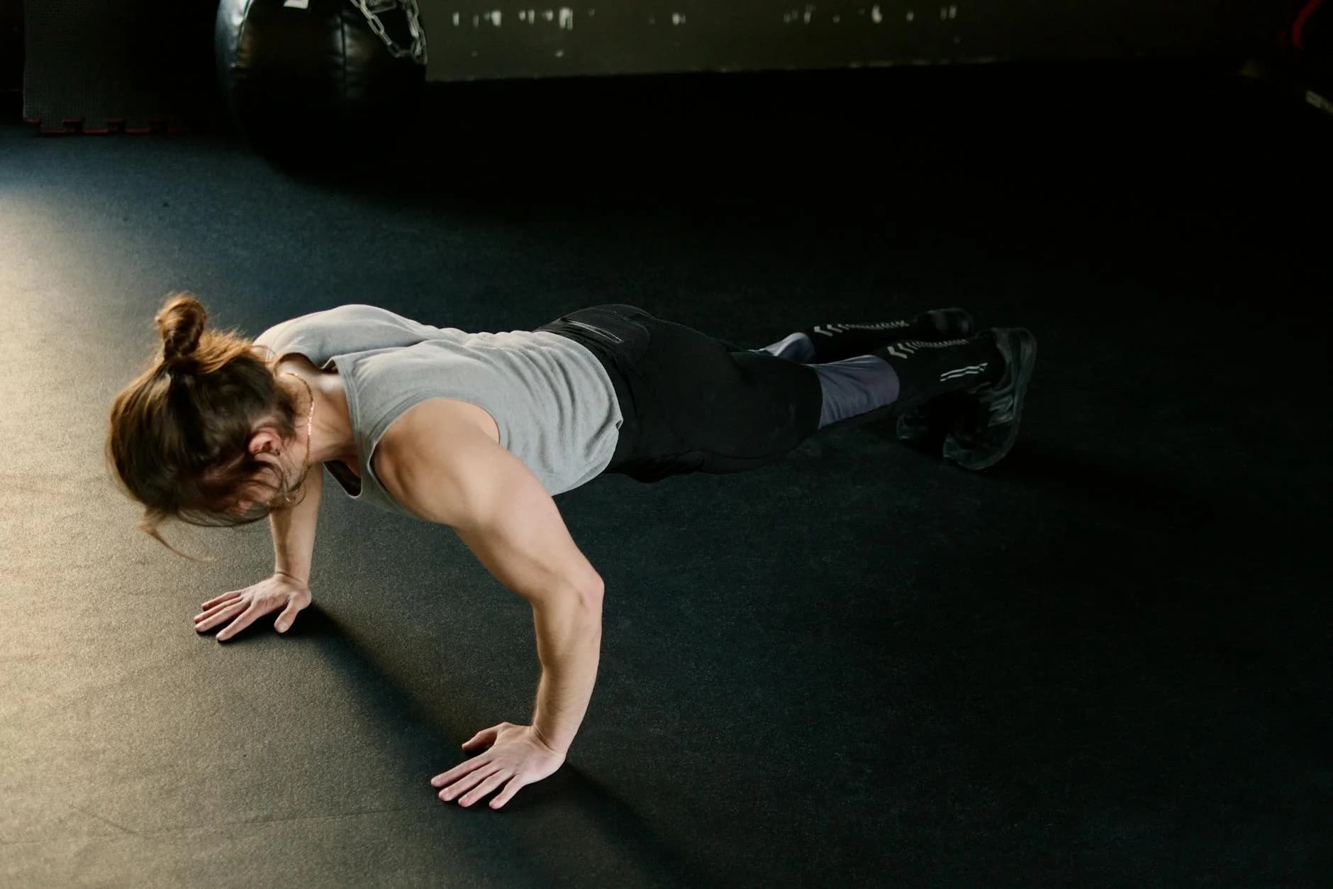 Hombre adulto haciendo flexiones en el suelo del gimnasio