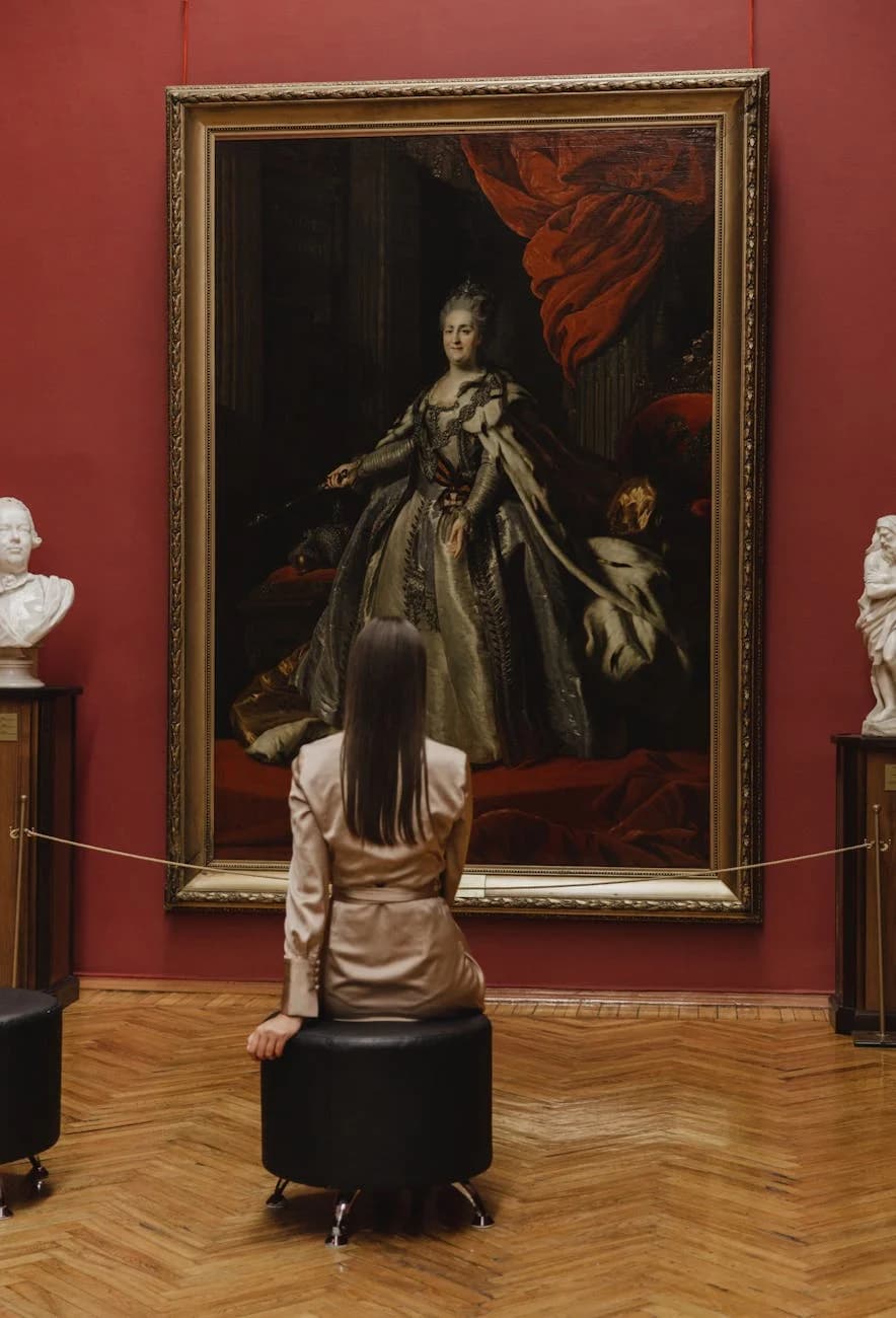 Una mujer sentada en una galería de arte observando una obra