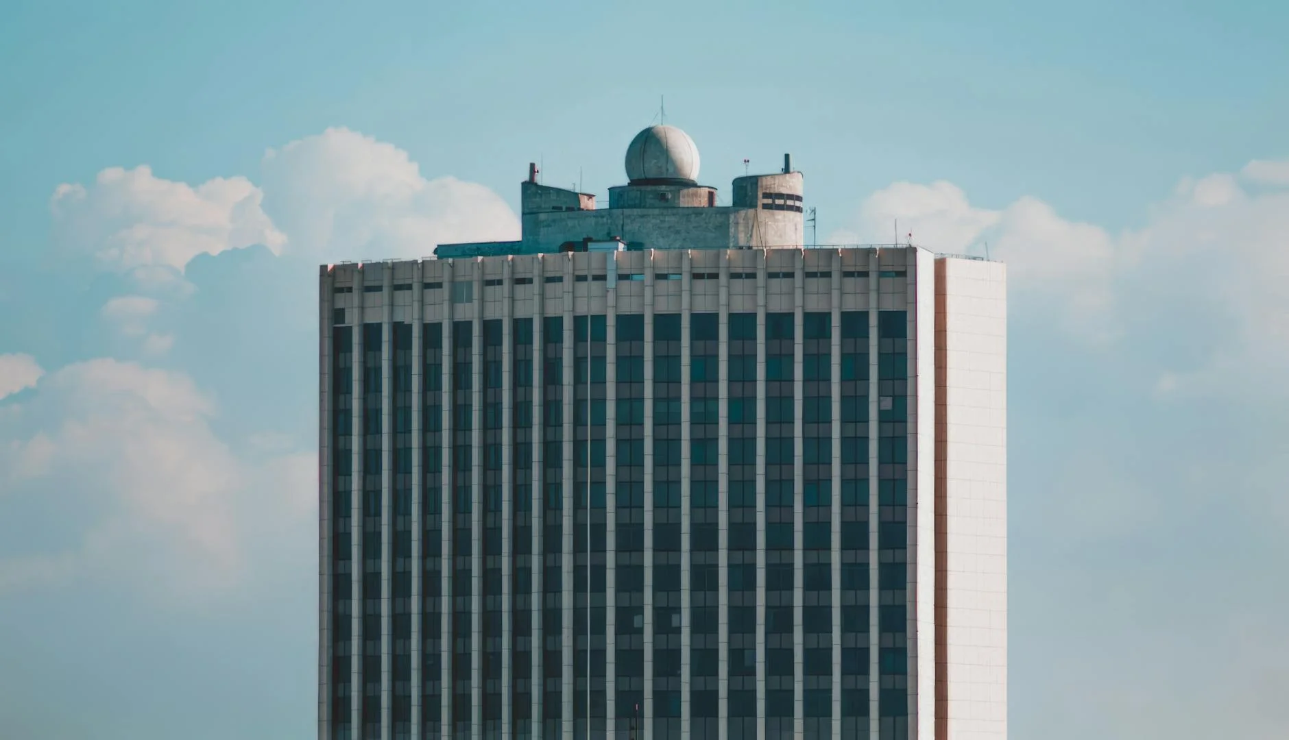 A High Rise Building With A Dome Against 4