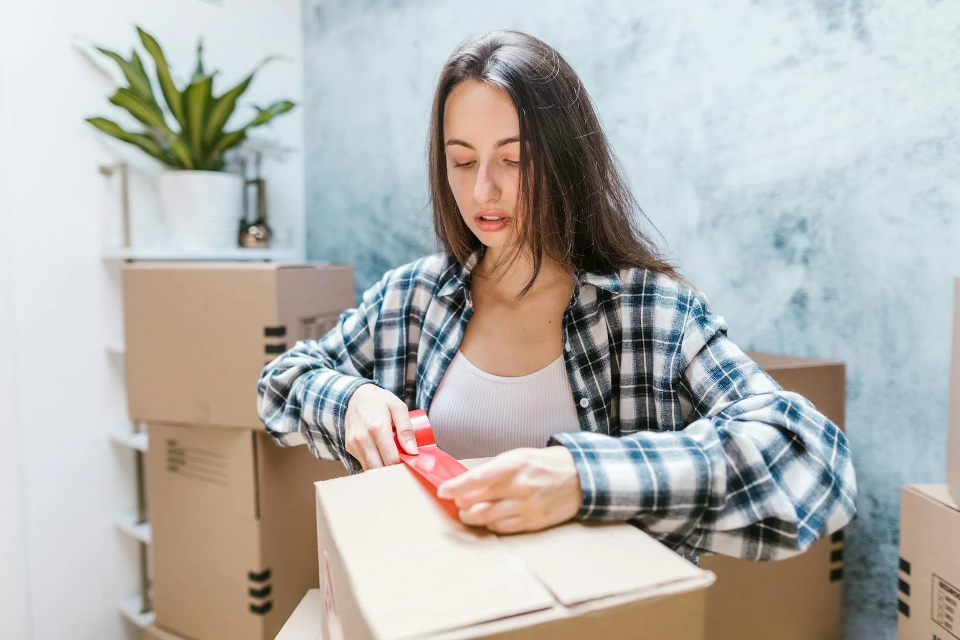 Woman Sealing Boxes With Tape For Reloca 4