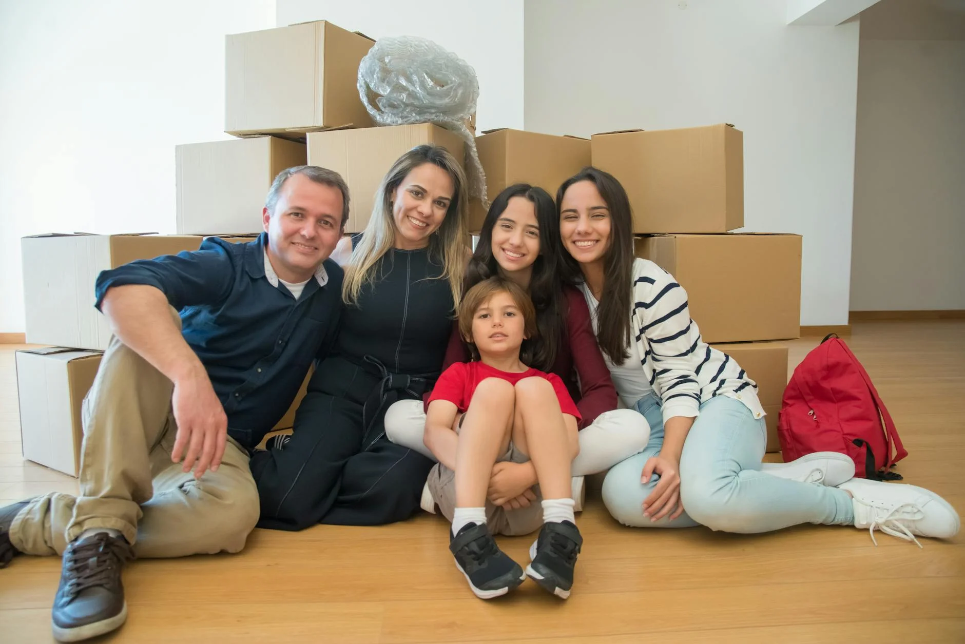 Una familia feliz sentada juntos con cajas de mudanza