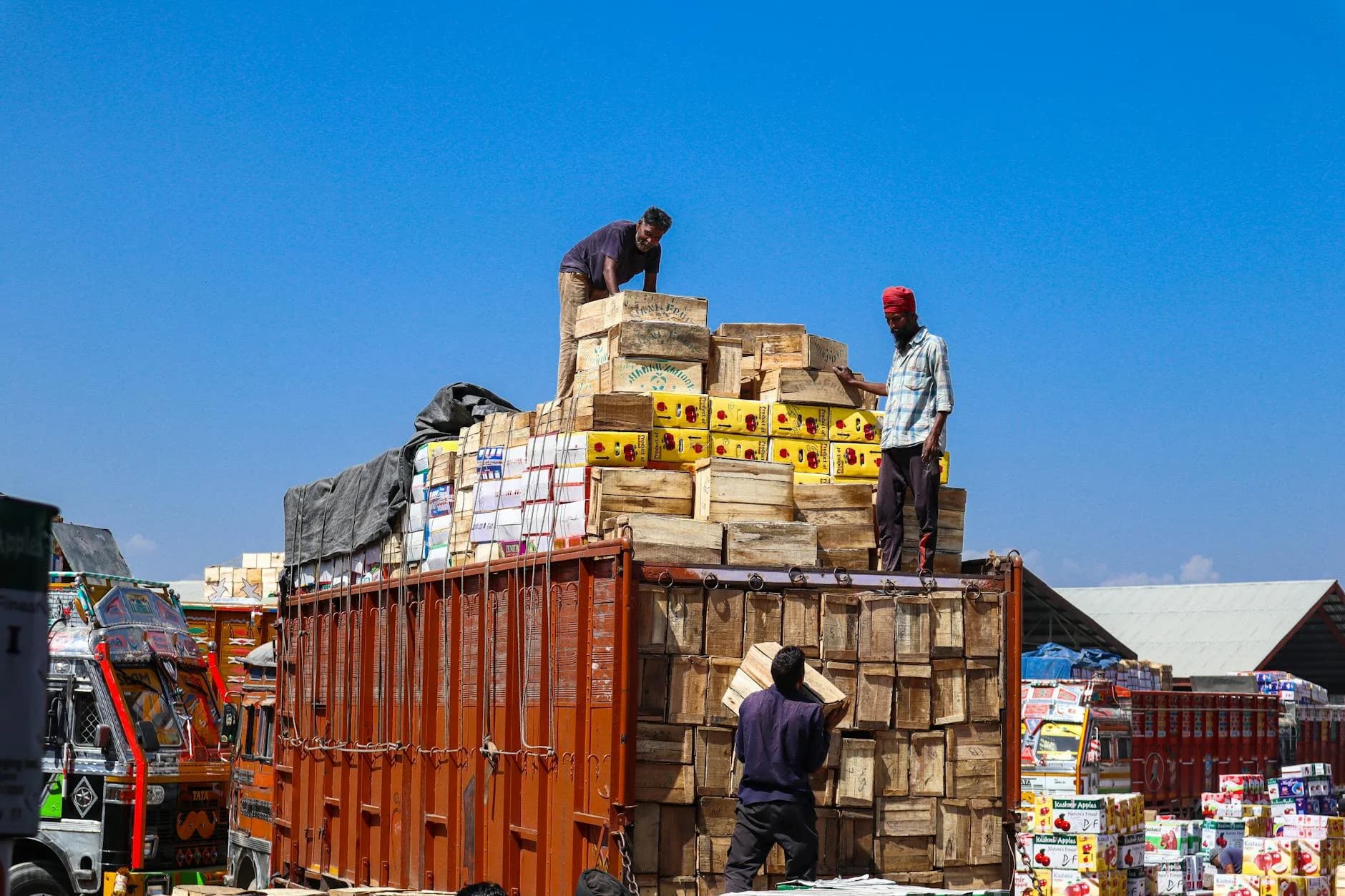 Tres Hombres Cargando Cajas de Madera en un Camión
