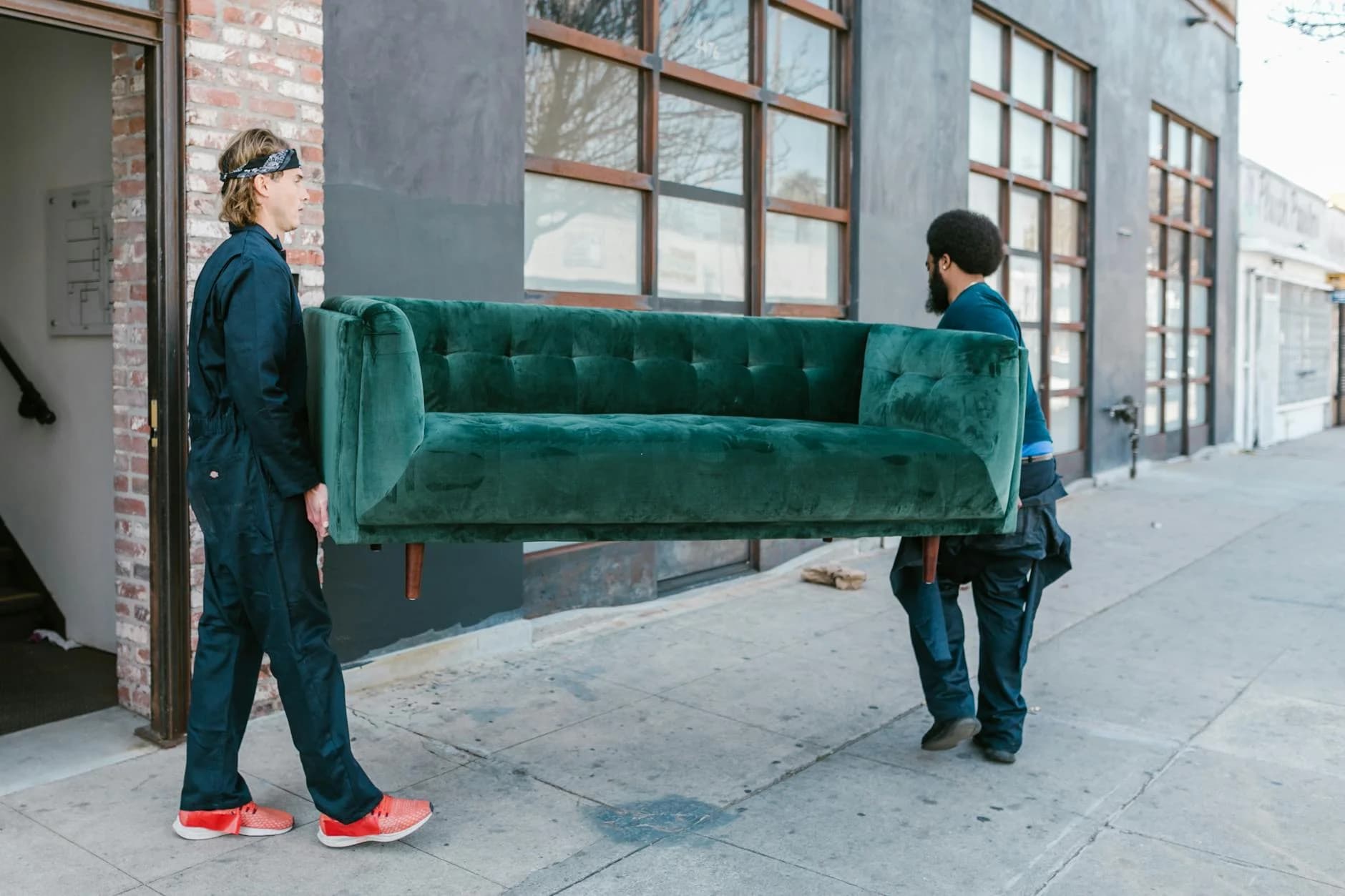 Two Men Carrying A Green Sofa On A City 3