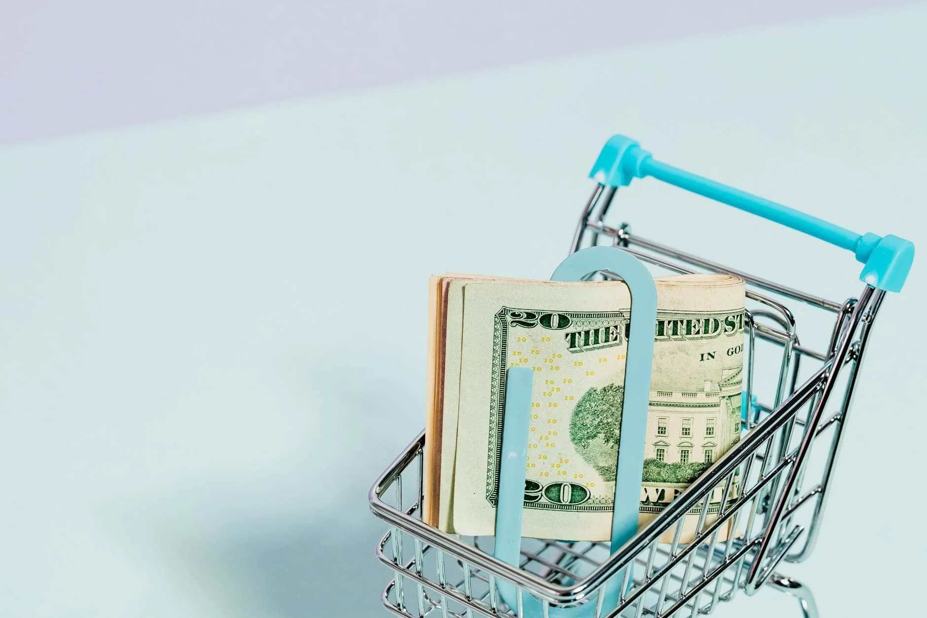 A Shopping Cart Holding A Stack Of Us Do 1