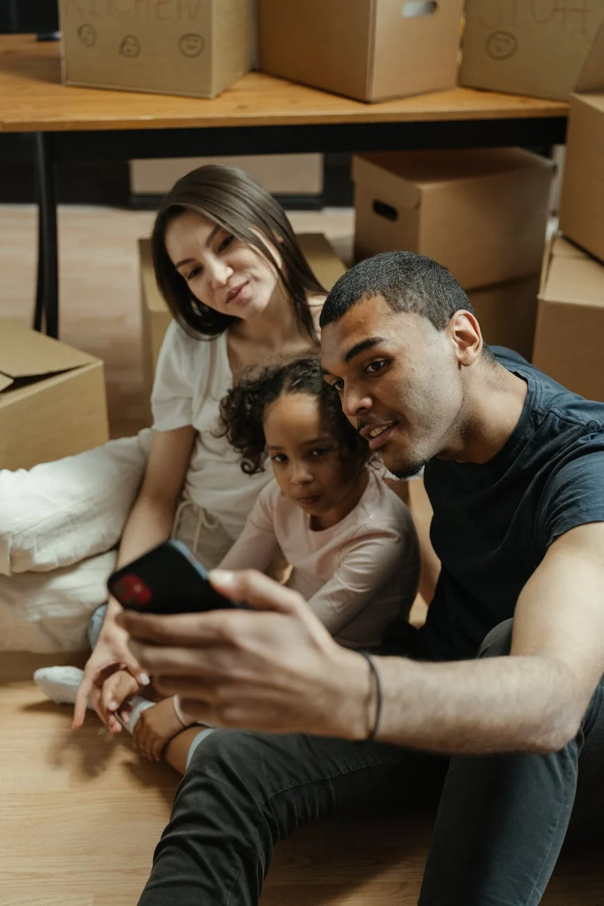 Familia disfrutando un selfie mientras están rodeados de cajas
