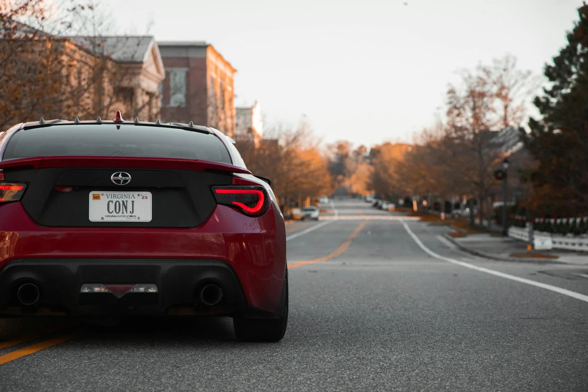 A Red Sports Car Drives Down A Quiet Sub 1