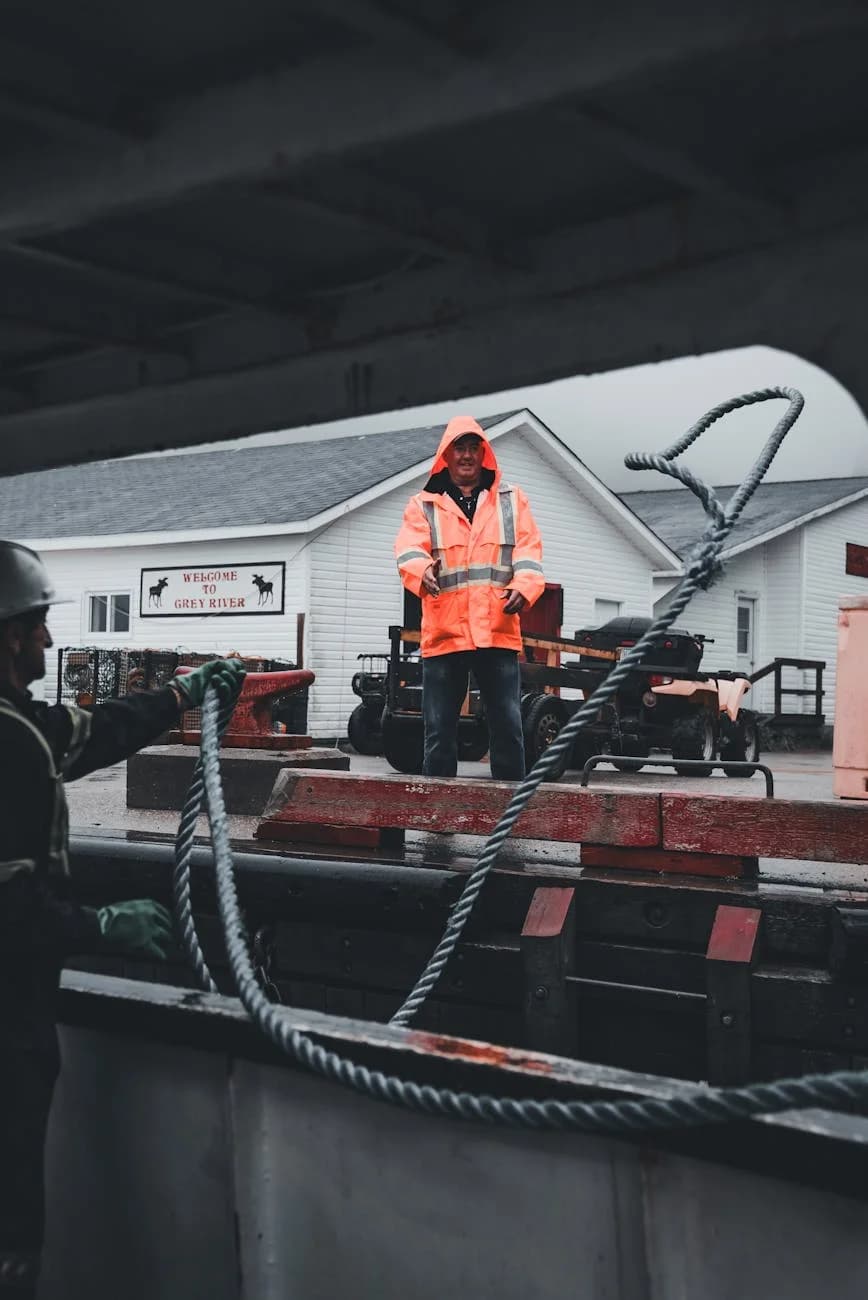 Trabajadores del muelle asegurando cuerdas en un área costera