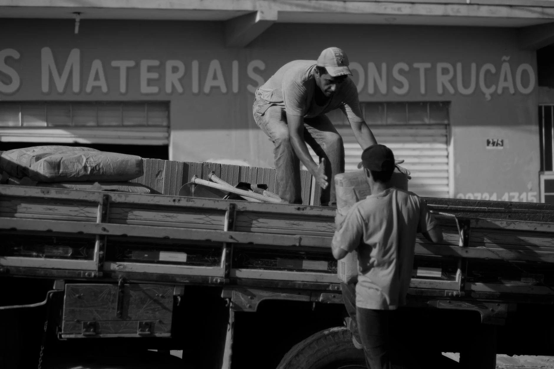 Dos hombres cargando materiales de construcción en un camión