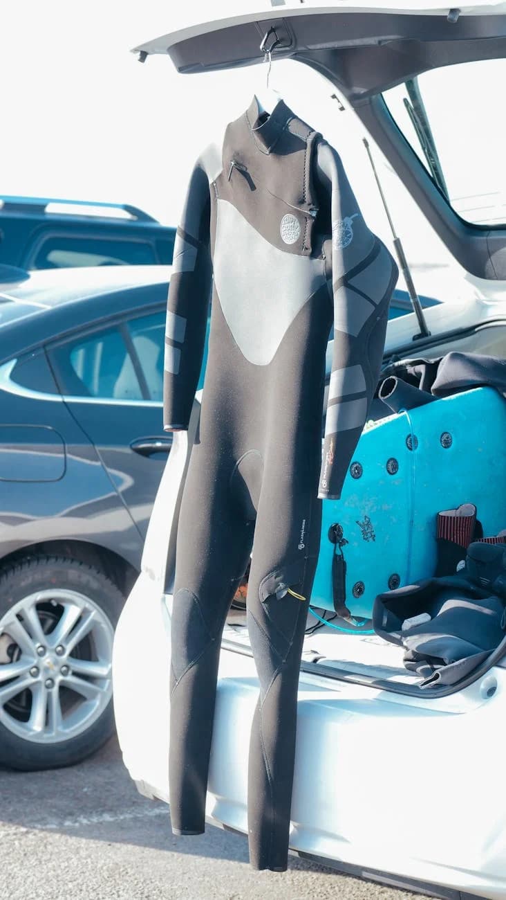 A Wetsuit Hanging From An Open Car Trunk 1