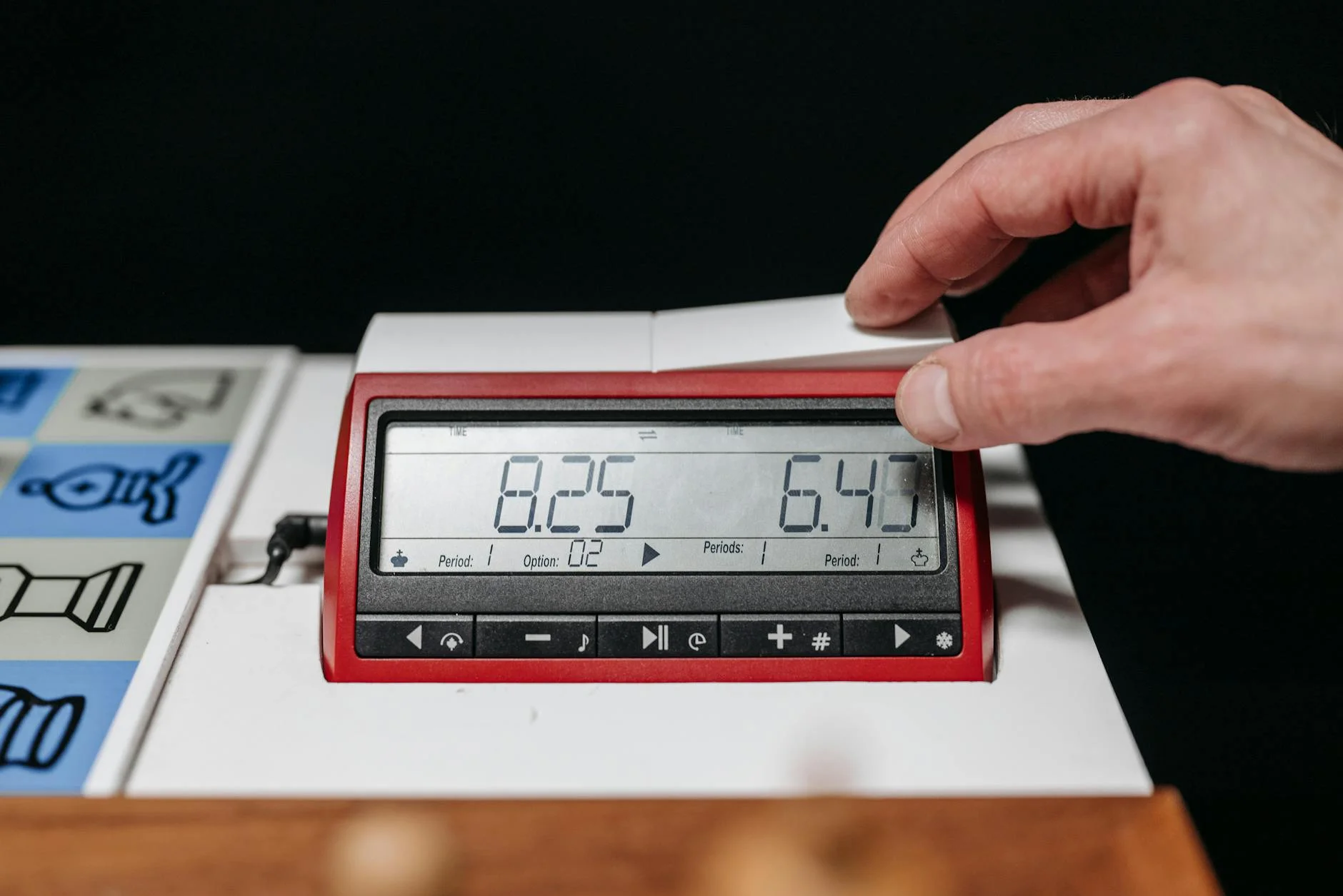 A Hand Adjusting A Digital Chess Clock D 2