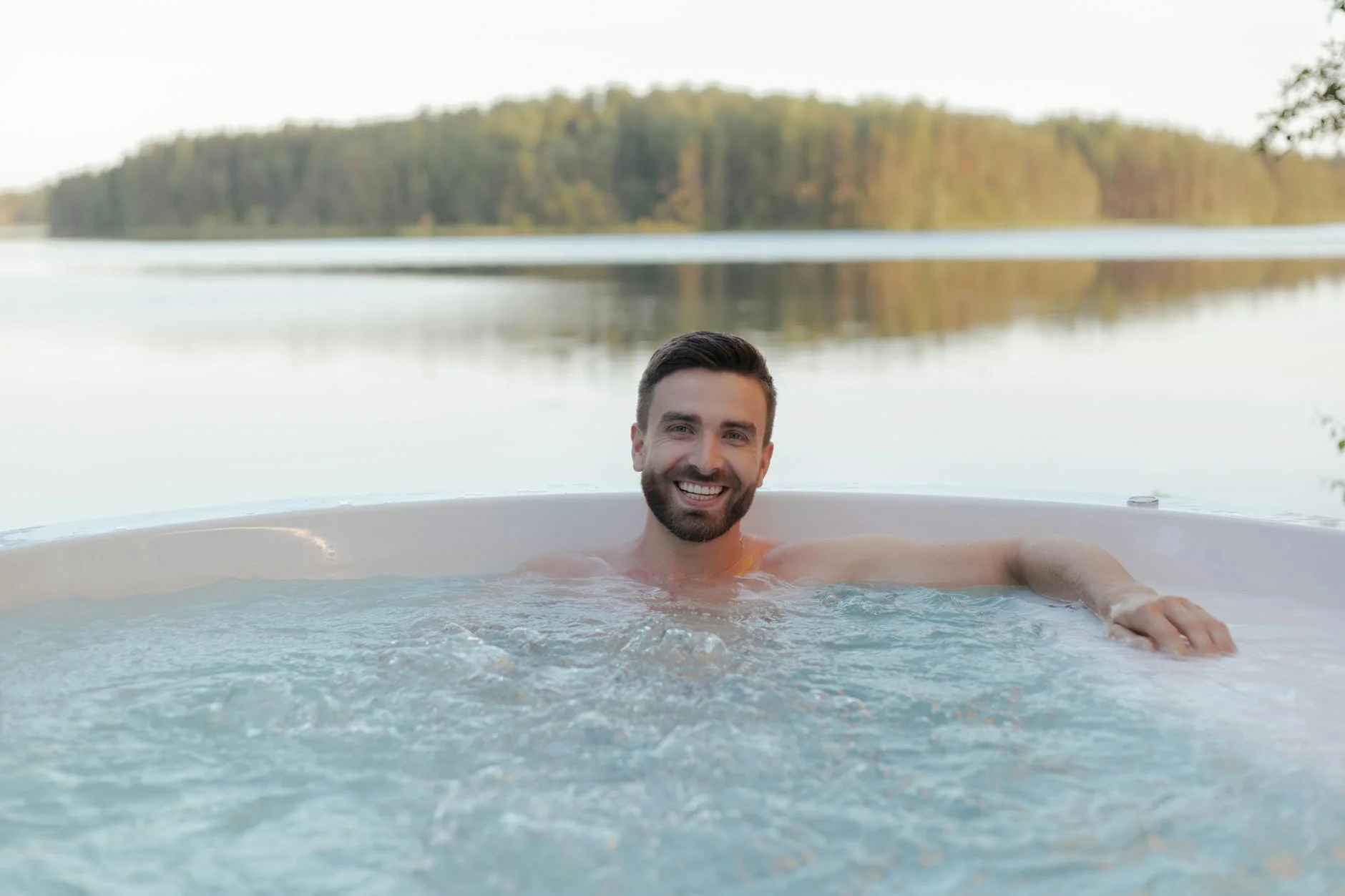 Hombre sin camisa sonriendo en jacuzzi exterior