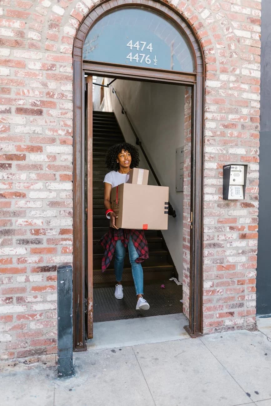 Young Woman Moving Boxes Out Of An Apart 3