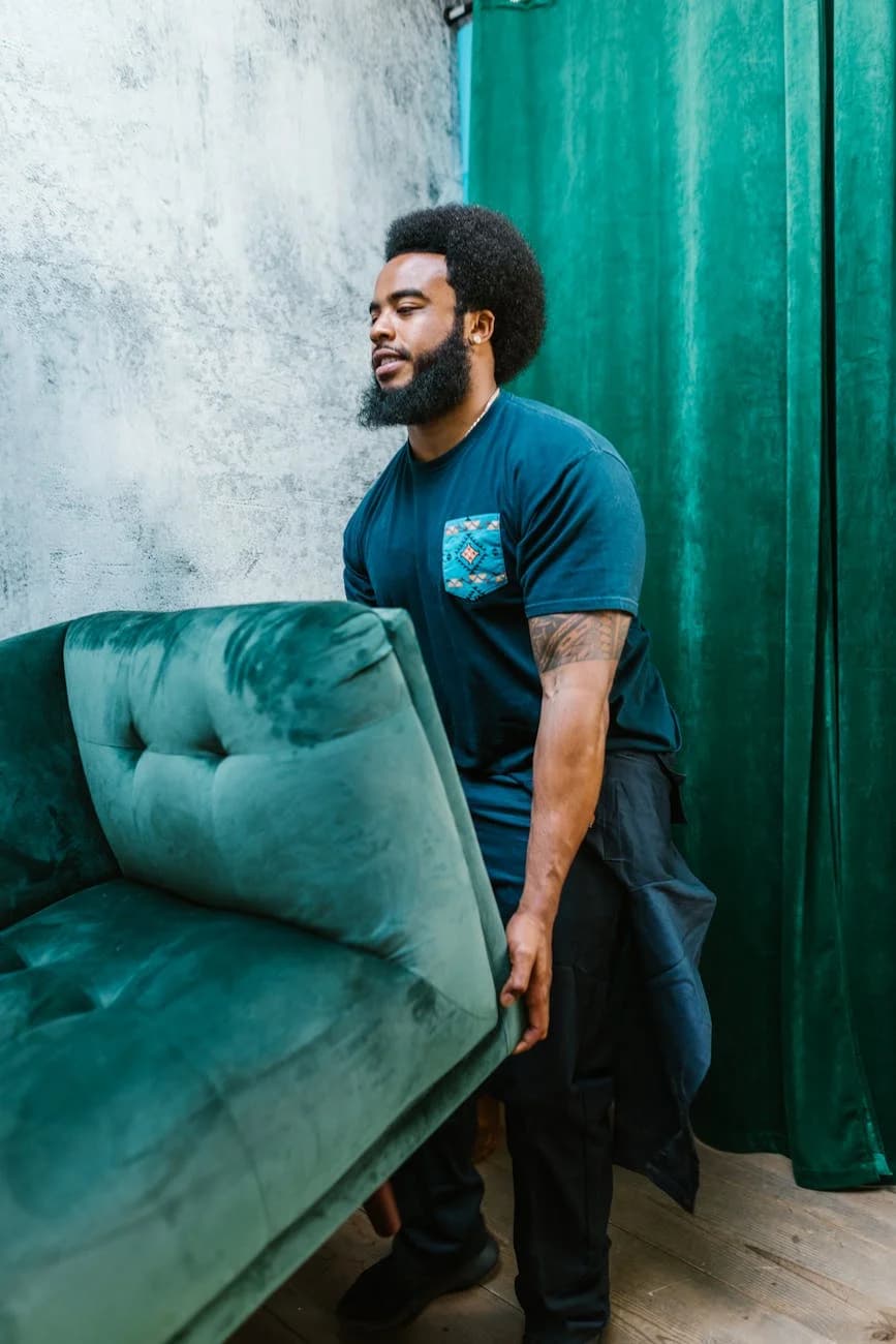 Bearded Man Carrying A Teal Velvet Couch 4