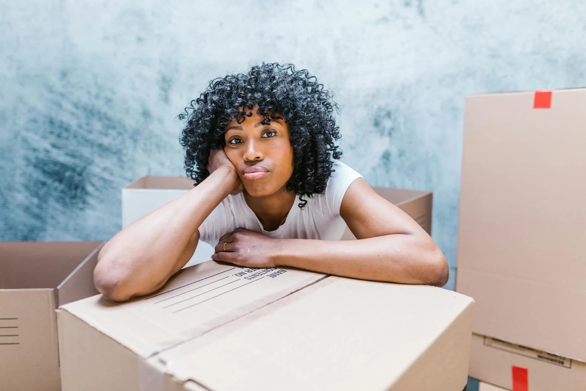 Tired Woman Leaning On A Moving Box Whil 2